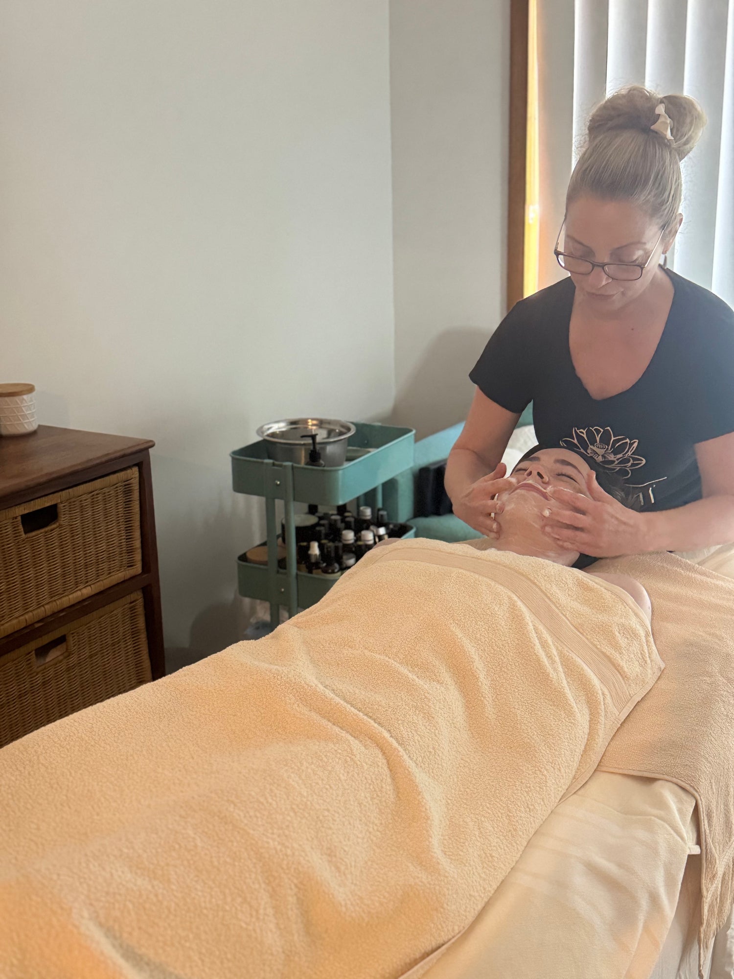 Person receiving a massage in a clinical setting with a towel draped over them.